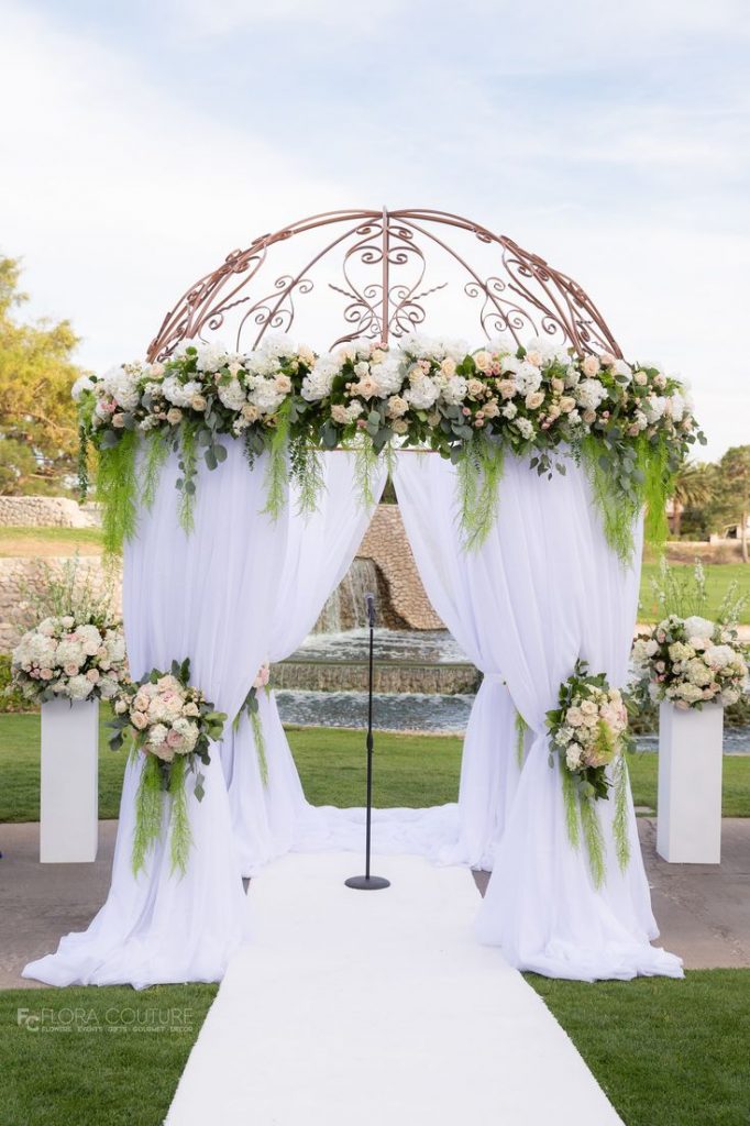Wedding gazebo pillors decorated with cascading tulle and flowers