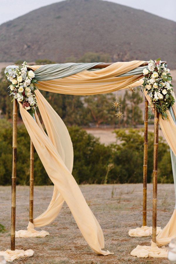 Wedding gazebo decorated with green and creme linen