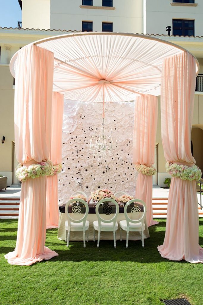 Wedding gazebo designed with champaign color curtains and roses