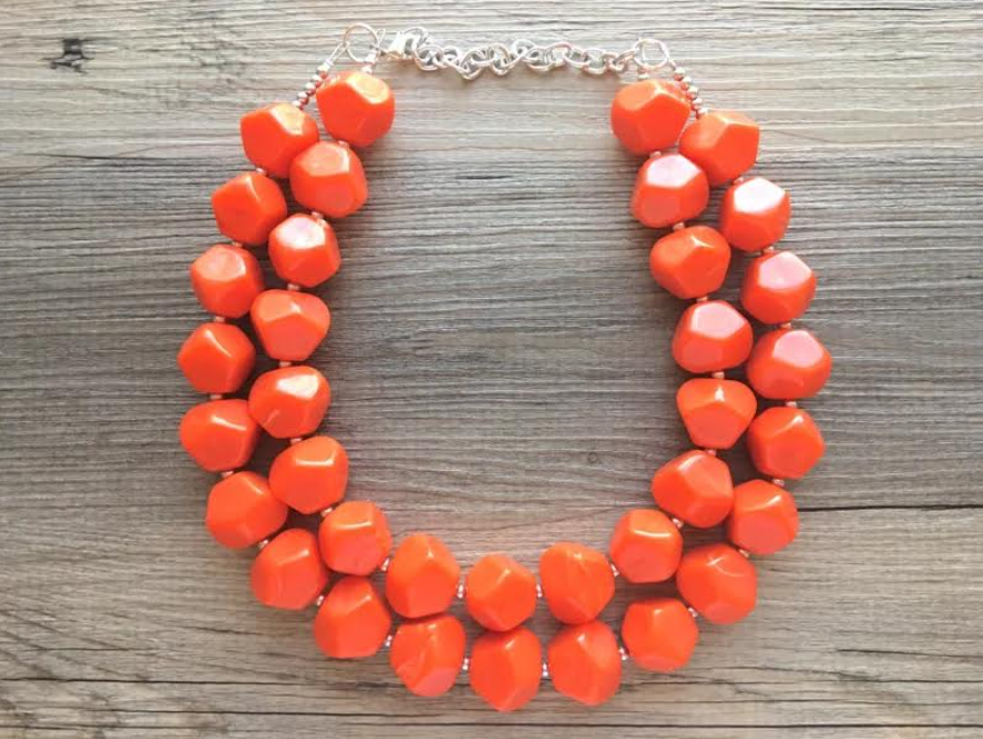 Coral-color necklace to accessorize navy-blue dress