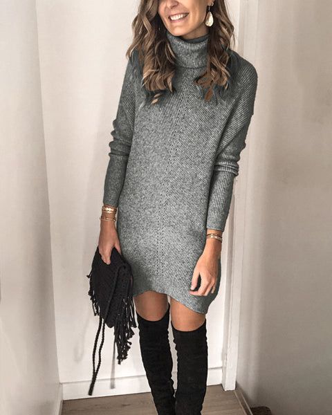 Sweater dress accessorized with golden bracelets and black purse